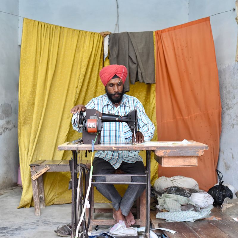 Darzi apni silai machine par kaam karte hue
